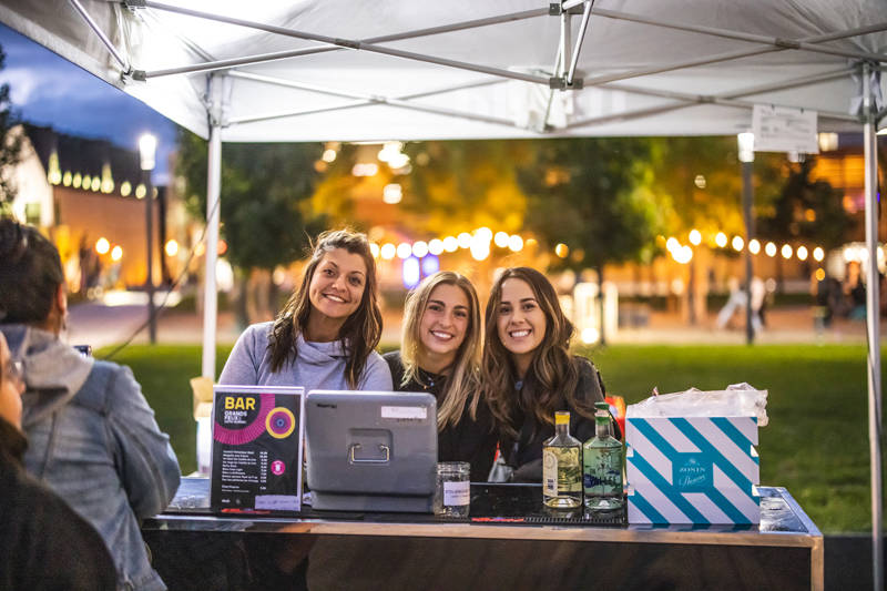 Three young women volunteering and smiling at the camera